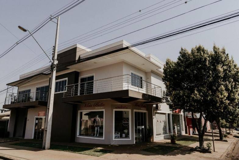 Fachada das salas comerciais com vitrines e sacada do apartamento
