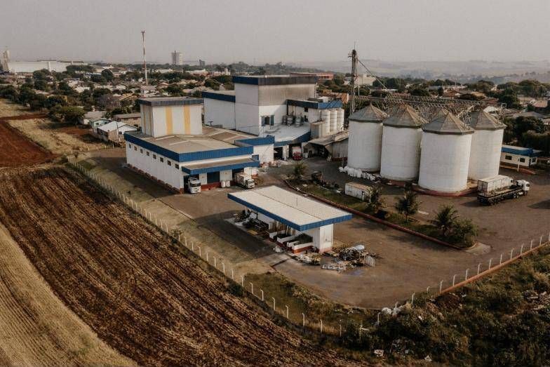 Moinho Consolata visto de drone, com silos e caminhões no pátio de expedição