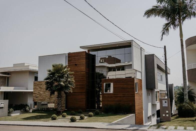 Fachada da Residência C.R com revestimento de madeira e pele de vidro